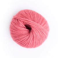 A single ball of pink yarn photographed from above on a clean white background.