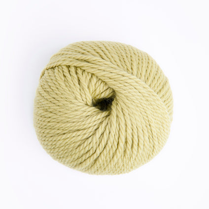 A ball of pale yellow yarn photographed from above on a clean white background.