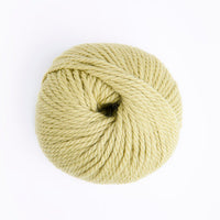 A ball of pale yellow yarn photographed from above on a clean white background.