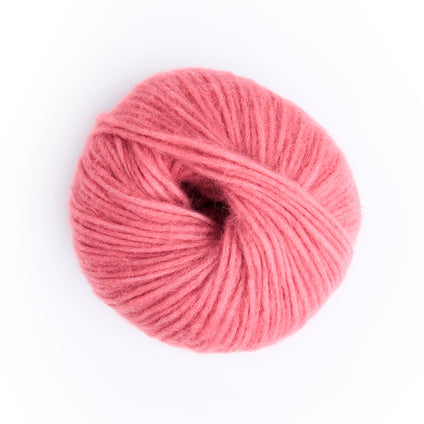 A single ball of pink yarn photographed from above on a clean white background.